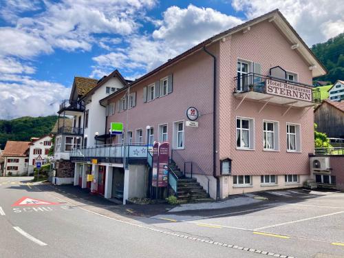 a pink building on the side of a street at Garni Sternen in Obstalden