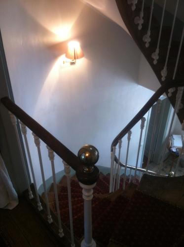 a light on the wall next to a staircase at O Mylle Douceurs in Le Crotoy