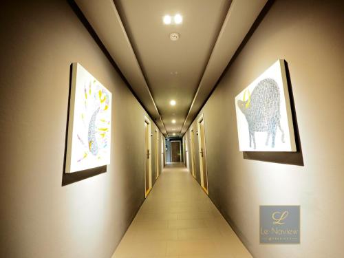 a long hallway with two paintings on the walls at Le Naview @Prasingh in Chiang Mai