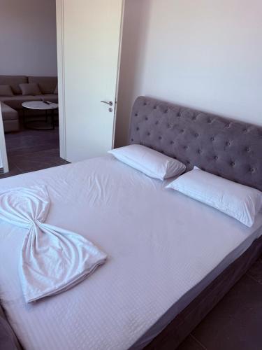 a large bed with white sheets and pillows on it at Rana Hedhun Seaside 1 in Lezhë