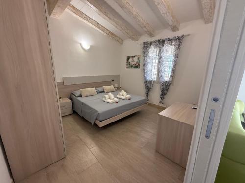 a bedroom with a bed and a table in it at casa vacanza La Collina in Cugnana Verde