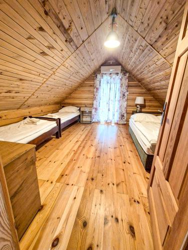 a large room with two beds and a wooden floor at Highland Warmia - Gospodarstwo agroturystyczne in Jeziorany