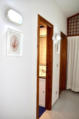 a hallway with a door open to a kitchen at Casa Lucia vicino al mare in Budoni