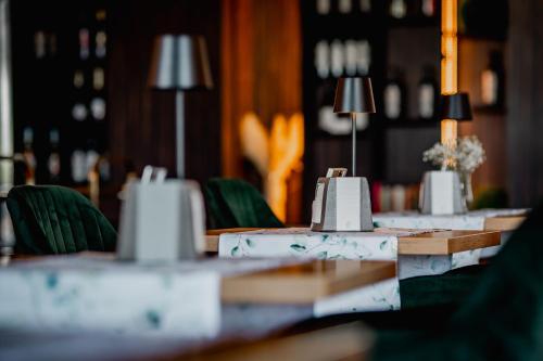 a long table with green chairs and lamps at Hotel Mistral Sport in Gniewino