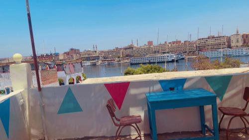 a balcony with chairs and a table and a view of a city at Fekry home in Aswan