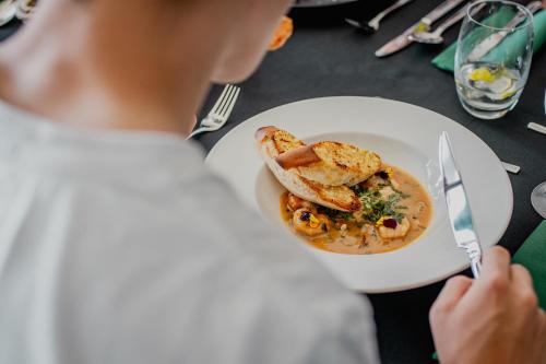 a person sitting at a table with a plate of food at Hotel Mistral Sport in Gniewino