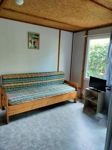 a bedroom with a wooden bed in a room with a window at 13 vents in Castanet