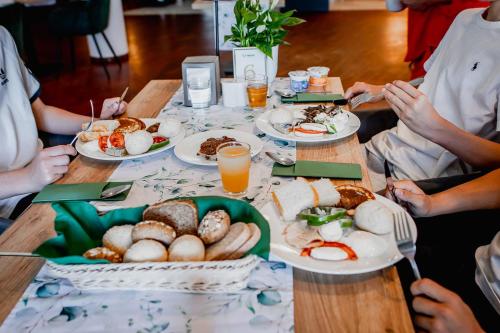 a group of people sitting around a table with plates of food at Hotel Mistral Sport in Gniewino