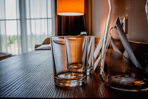 a empty glass sitting on a wooden table at Hotel Mistral Sport in Gniewino