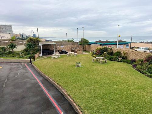 a park with picnic tables on a grass field at Unit 102 Warnadoone in Kingsburgh