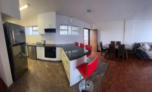 a kitchen and living room with a table and a couch at Unit 102 Warnadoone in Kingsburgh