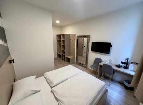 a bedroom with a bed and a desk with a computer at Hotel Evropa in Celje