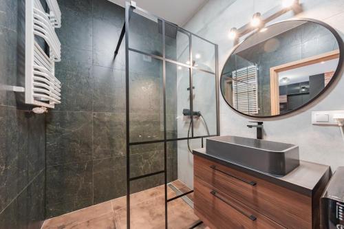 une salle de bains avec un lavabo et un miroir dans l'établissement Apartament Loft & glow Montownia, à Gdańsk