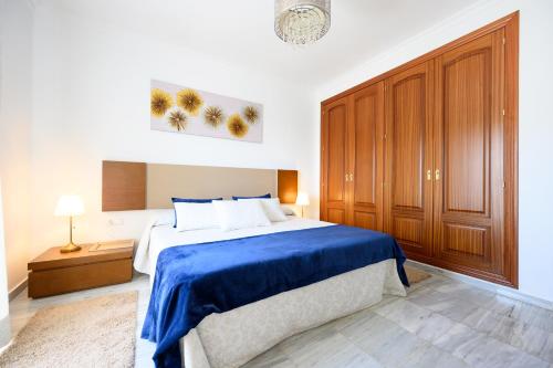 ein Schlafzimmer mit einem großen Bett mit einer blauen Decke in der Unterkunft VILLA INTMA - GOLF - POOLS - near Mijas, Marbella, Fuengirola - Fully Equipped in Alhaurín el Grande