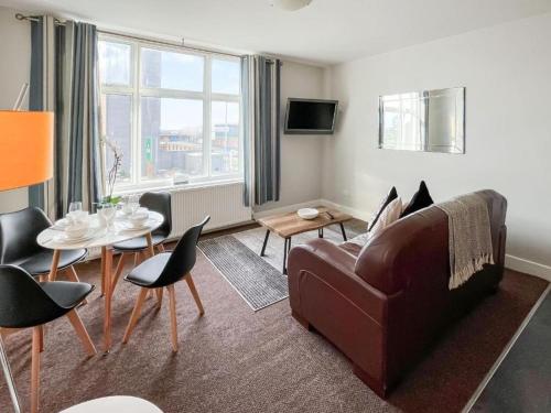 a living room with a couch and a table at Pier View Skegness in Skegness