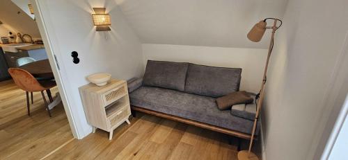 a couch in a room with a lamp and a table at Amrum Lounge - Stilvolle Ferienwohnung mit Gartenidylle in Nebel