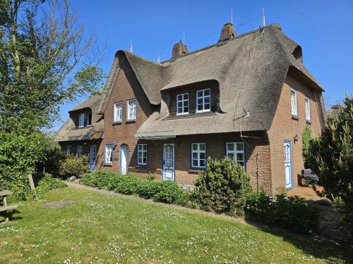 a large brick house with a gambrel roof at Amrum Lounge - Stilvolle Ferienwohnung mit Gartenidylle in Nebel