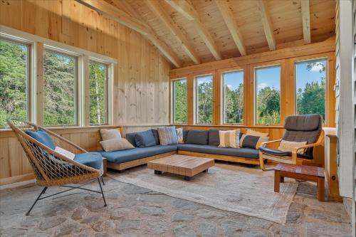 Una sala de estar con un sofá azul y sillas. en 4 Br Sleeps 8 - Kayaks - Fire Pit - Dog Friendly, en Danville
