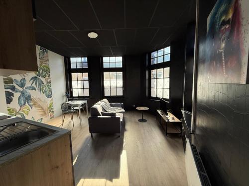 a living room with black walls and windows at La Symphonie 2 Charmant appartement en centre-ville in Gravelines