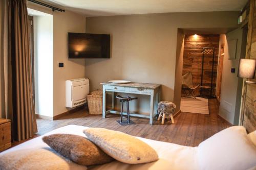 a bedroom with a bed and a desk with a television at Ca d' Vetu in Roccaforte Mondovì