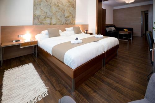 a bedroom with a large bed and a living room at Hotel Bartoš in Frenštát pod Radhoštěm