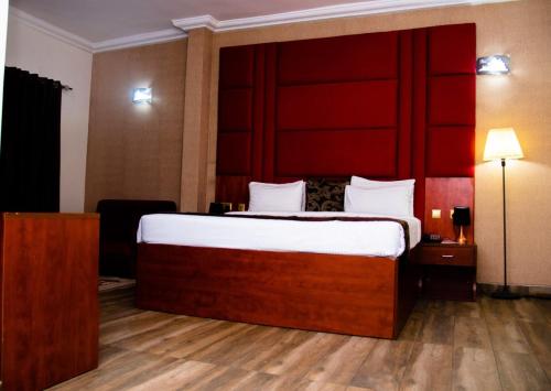 a bedroom with a large bed with a red headboard at Golden Tulip Hotel -GT31 Stadium Road in Port Harcourt