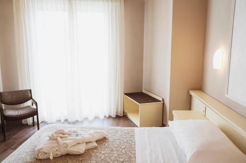 a bedroom with a bed with a towel on it at Hotel Terme Marconi in Montegrotto Terme