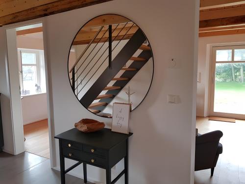 a hallway with a circular mirror and a black table at Schäferhaus in Hemme