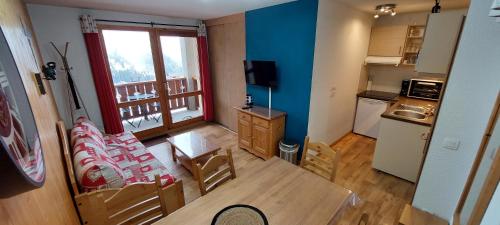 a living room with a table and a kitchen at Appartement Valmeinier 1800 in Valmeinier