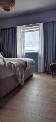 a bedroom with a bed and a window at Doonmore Hotel, Bar & Restaurant in Inishbofin