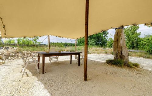 a table and a chair under a large umbrella at Charmant Gîte En Campagne in Palluau-sur-Indre