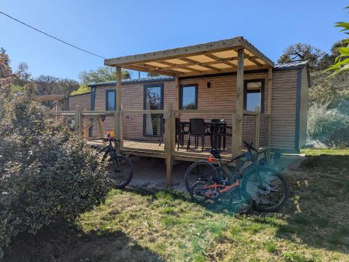 a tiny house with two bikes parked in front of it at Mobil home climatisé avec piscine in Viviers