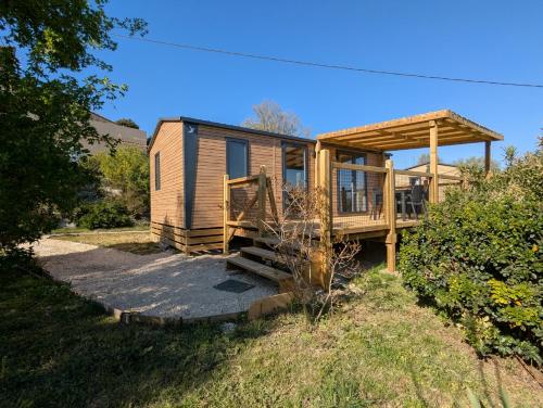 a tiny house with a porch and a deck at Mobil home climatisé avec piscine in Viviers