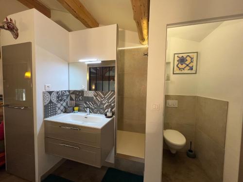 une salle de bain avec un lavabo et des toilettes dans l'établissement La Louvière des Bruyères, à Robion