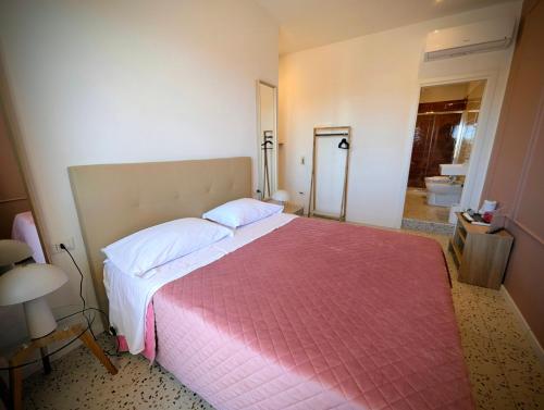 a bedroom with a large bed with a pink blanket at Incoming Municipio in Naples