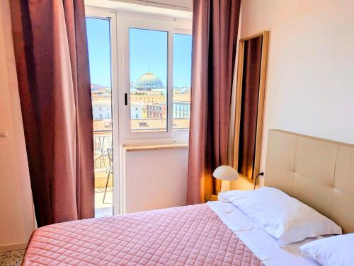 a bedroom with a bed and a large window at Incoming Municipio in Naples