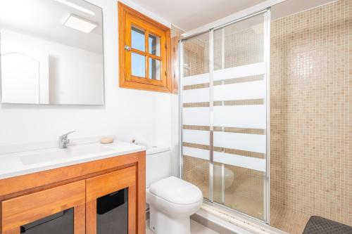 a bathroom with a toilet and a glass shower at Ca Na Martina in Cala d´Or