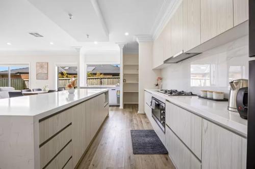 a large white kitchen with white counter tops and appliances at New Family Beach Home Near Geelong, St Leonards in Saint Leonards