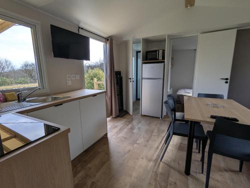 a kitchen and dining room with a table and chairs at Mobil home climatisé avec piscine in Viviers