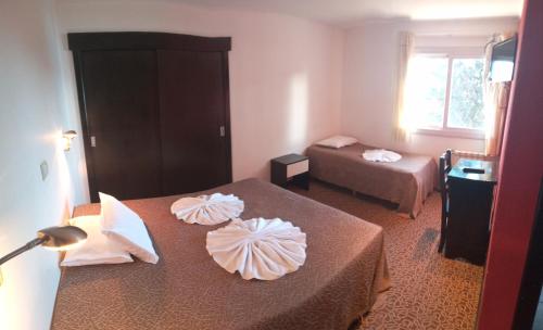 a hotel room with two beds and a table at HPP Hotel in San Carlos de Bariloche