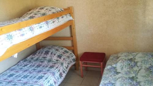 - une chambre avec deux lits superposés et une chaise rouge dans l'établissement Camping Europa Beach, à Castellare-di-Casinca