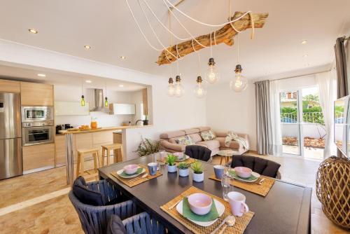 a kitchen and living room with a table and chairs at Villa Calma in Can Picafort