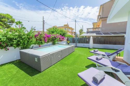 a backyard with a swimming pool and grass at Villa Calma in Can Picafort