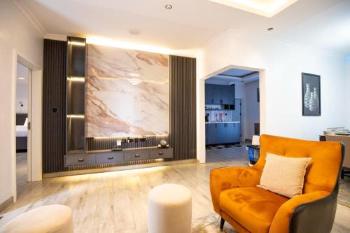 a living room with an orange chair and a large painting on the wall at Chic, comfortable house for Rent with Honore Rwanda in Kigali