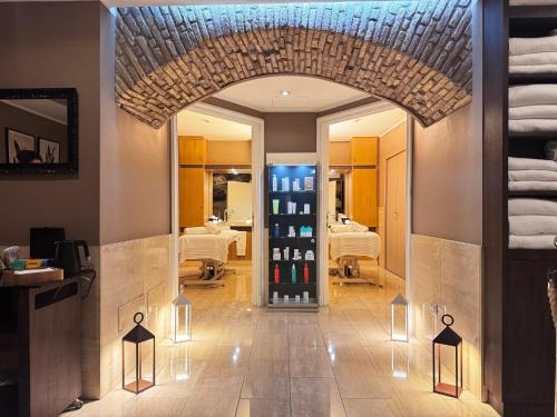 a hallway with an archway with a massage room in the background at Hotel Indigo Rome - St. George by IHG in Rome