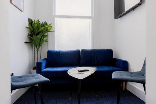 a blue couch in a living room with a table at Upper Berkeley Hotel in London