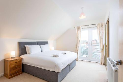 a bedroom with a large bed and a large window at The Portland Penthouse - Donnini Apartments in Troon