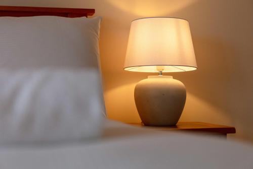 a lamp sitting on a table next to a bed at The Portland Penthouse - Donnini Apartments in Troon