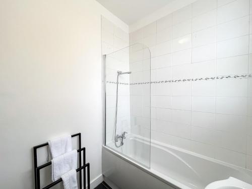 a white bathroom with a shower and a toilet at Spacious Camden Apartment D1 in London