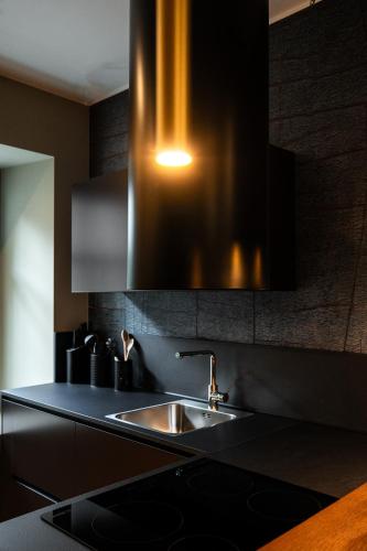 a kitchen with a sink and a light above it at Koderle Suite K2 Arnica in Brunico